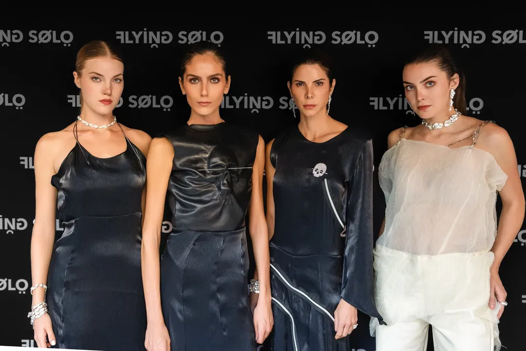Four models in VPLOSS looks in front of the Flying Solo wall
